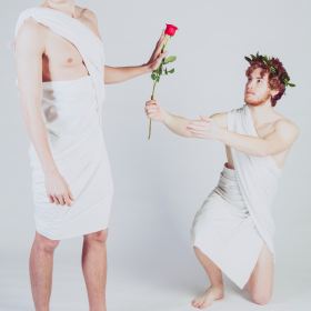 Man giving a rose to another man. Photo by Alessandro De Bellis on Unsplash