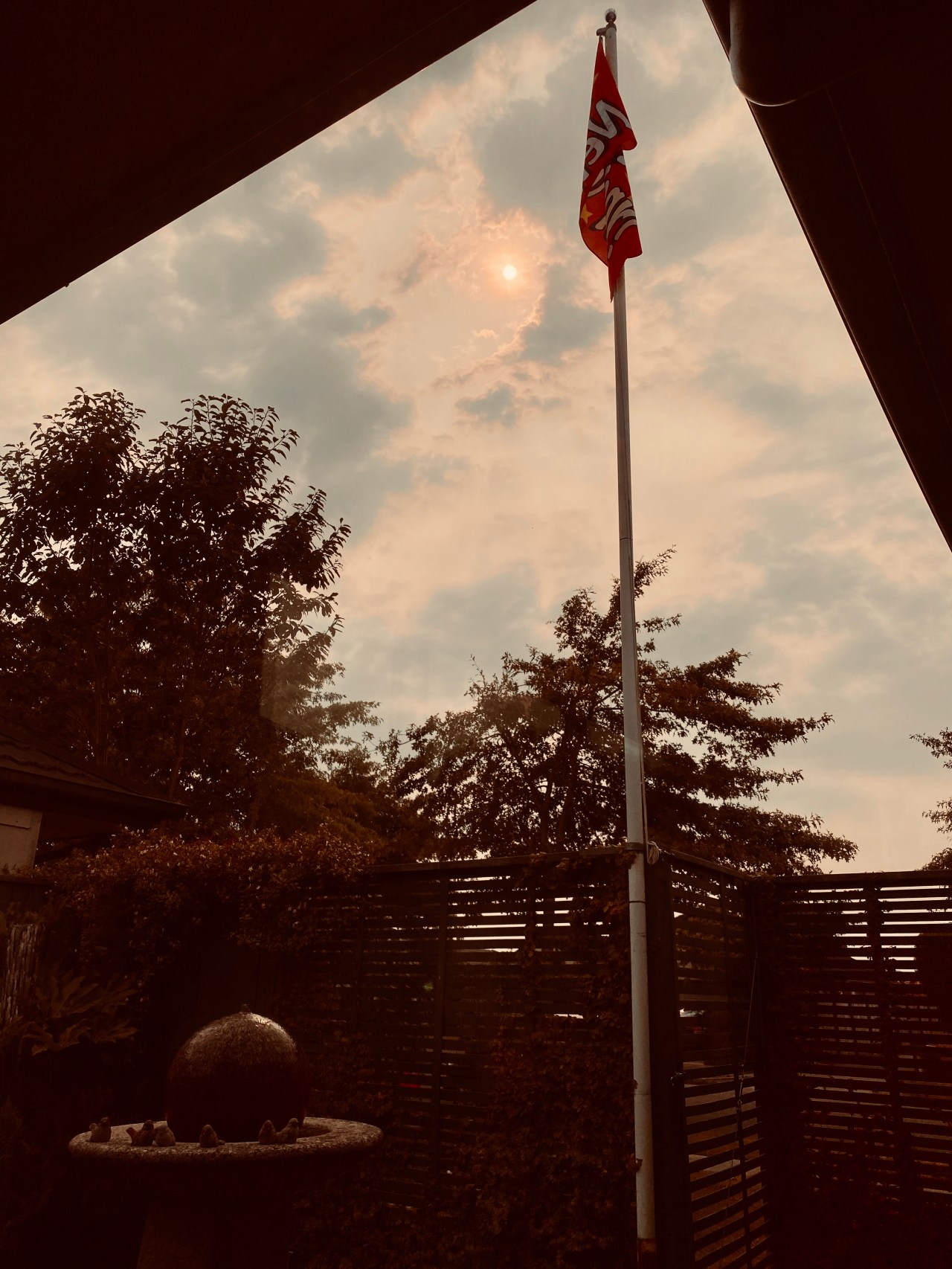 Flagpole and yard with sun in the yellow sky on 1 January 2020