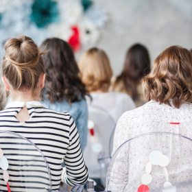 Backs of young female students in a classroom