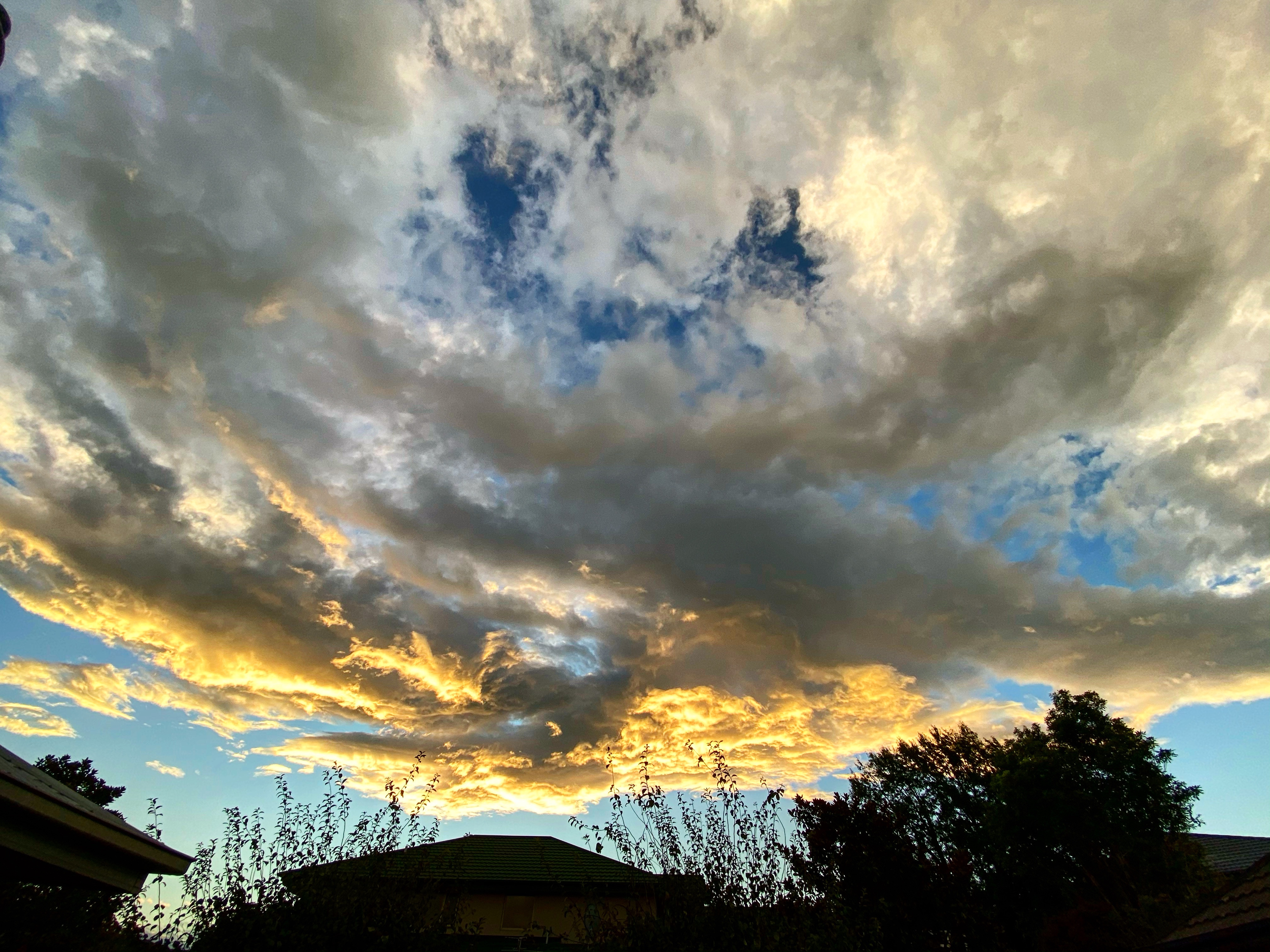 Clouds reflecting the yellows of sunset on a Nor'West'r' evening in autumn in Christchurch, New Zealand