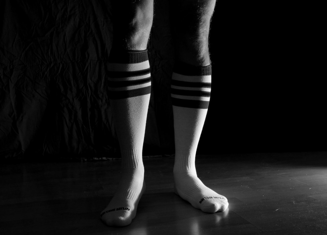 Knee-high athletic socks on a man's legs in black and white