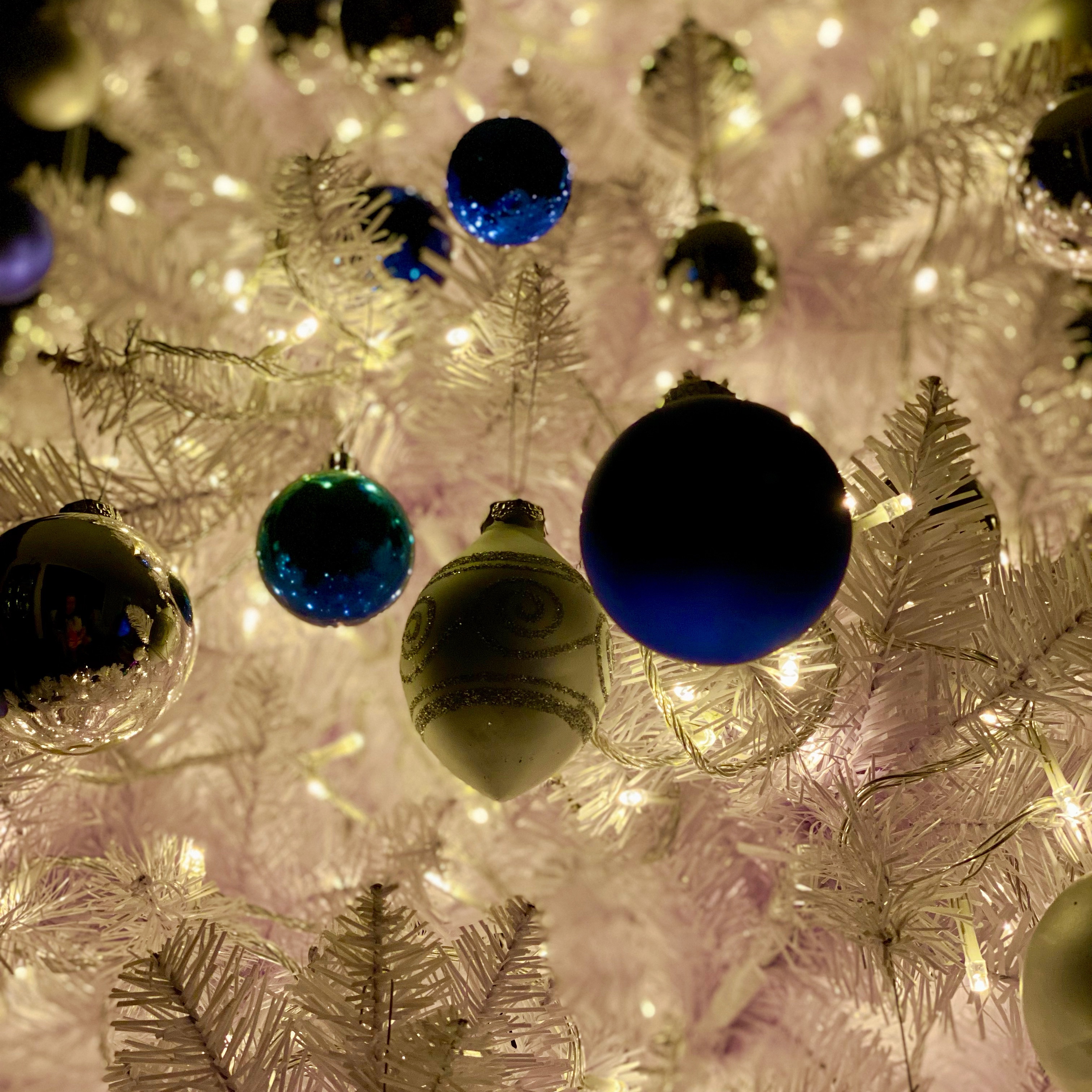 White Christmas tree with warm white LED lights and blue and silver ornaments