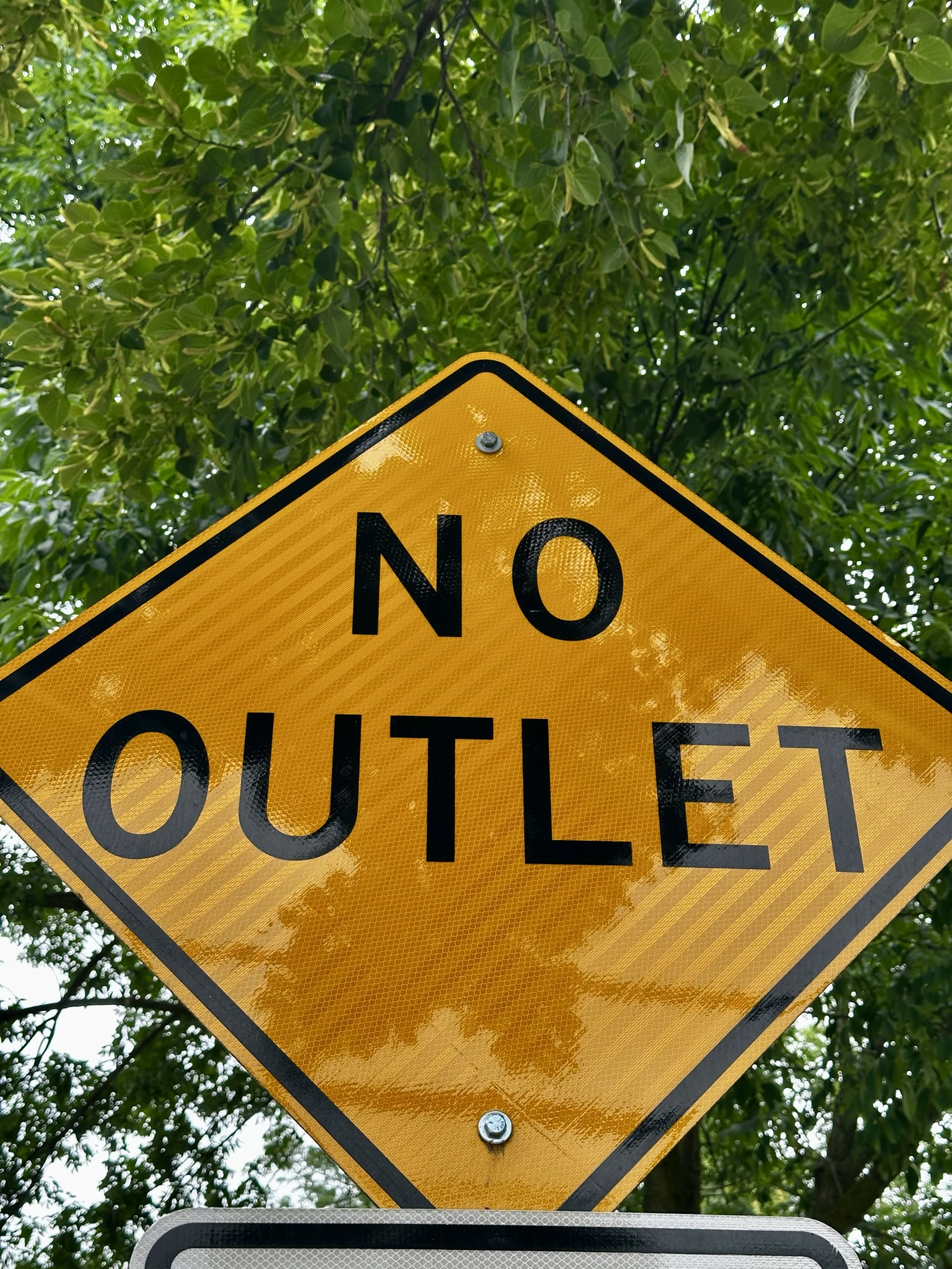 A yellow warning sign reading "No Outlet"