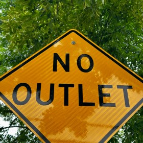 A yellow warning sign reading "No Outlet"